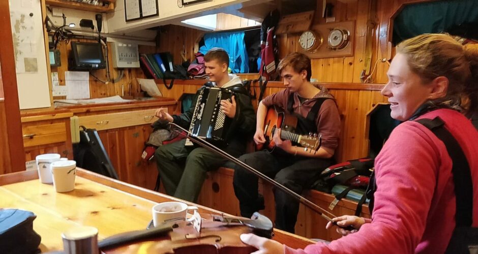 Sanday students play with Skipper Maggie Adamson during Swan sail training