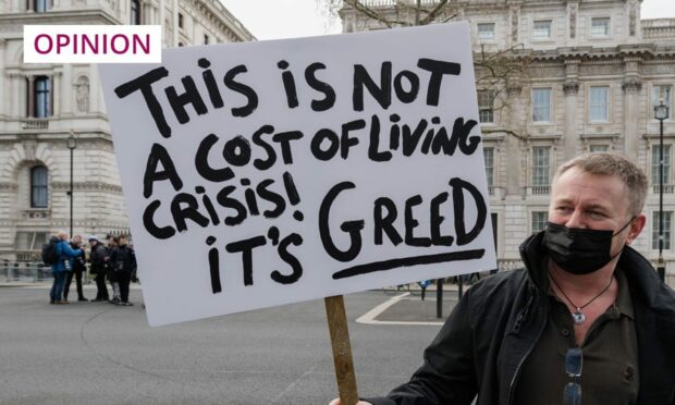 A demonstrator holds a placard during a protest outside Downing Street against rising household energy bills and inflation-driven price increases (Photo: Wiktor Szymanowicz/NurPhoto/Shutterstock)