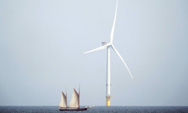 Sailing ship passes wind turbine