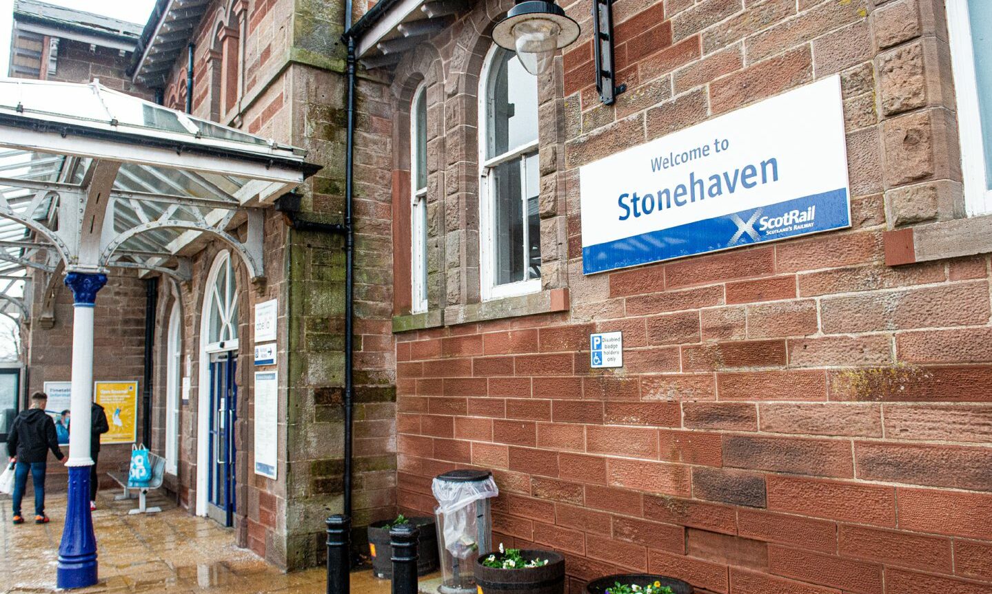 Stonehaven railway station with a sign reading "welcome to Stonehaven" on the wall