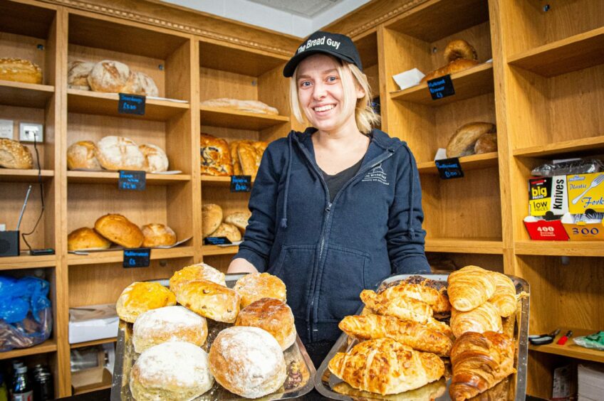 Tamzin Shepherd holds two trays of bakes with croissants and scones.
