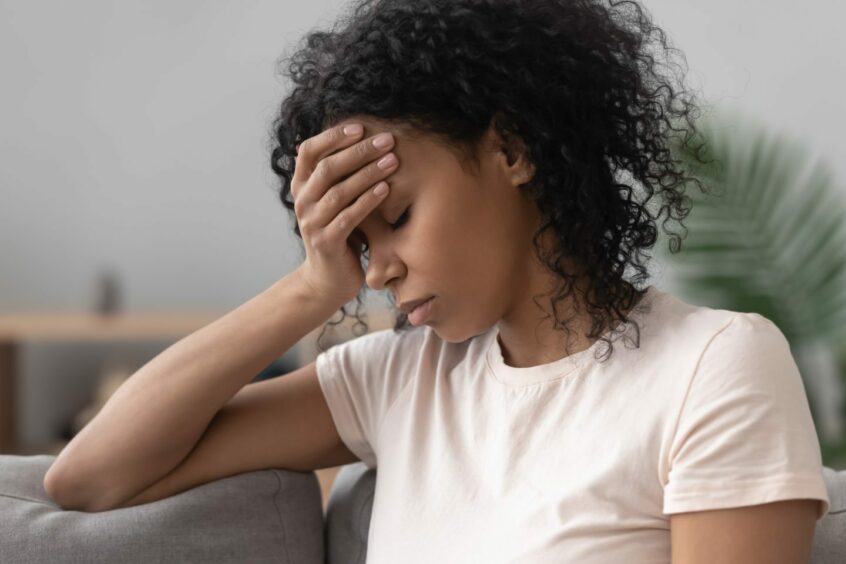 Depressed woman holding hand over her forehead