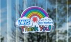 An NHS sticker on a window, with the words "NHS and all other key workers, Thank you!" in rainbow letters underneath a drawing of a rainbow