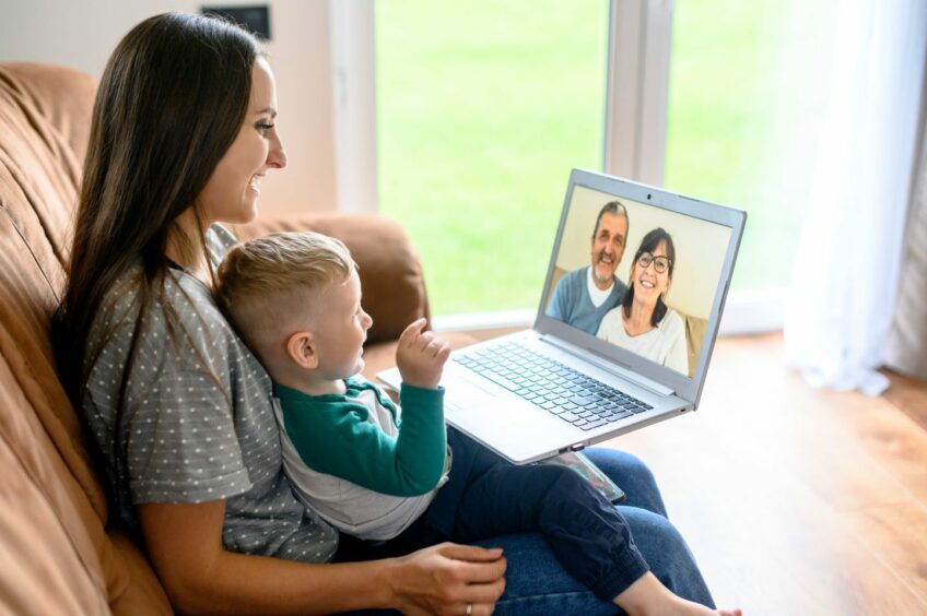 A mother and baby looking at a screen for a video call