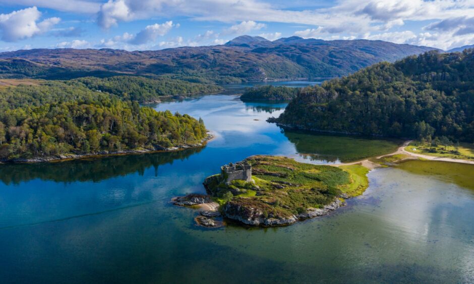A landscape of Castle Tioram which has been taken from above, showcasing the Scottish castle's island. 