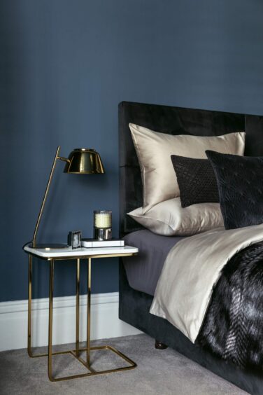 A contemporary decorated bedroom featuring black, silver and navy shades
