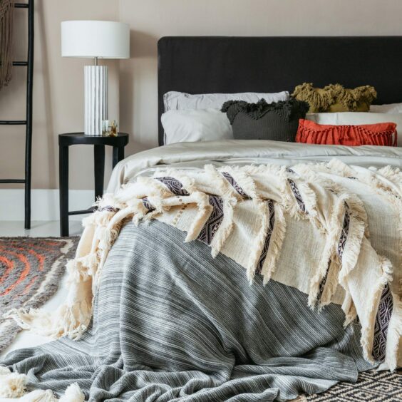 A bed with a selection of different textured cushions and throws