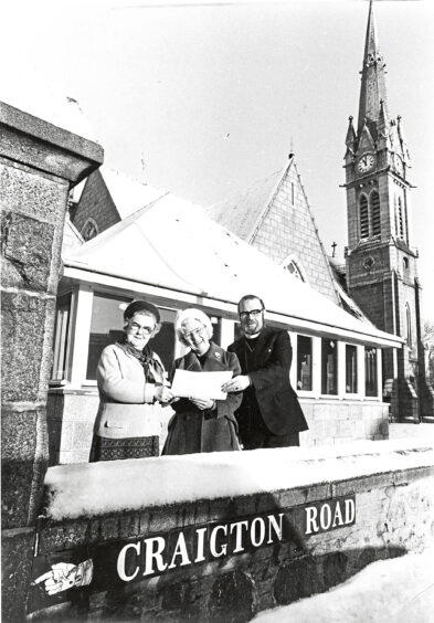 Three people stand outside Mannofield Church on Craigton Road in 1981.