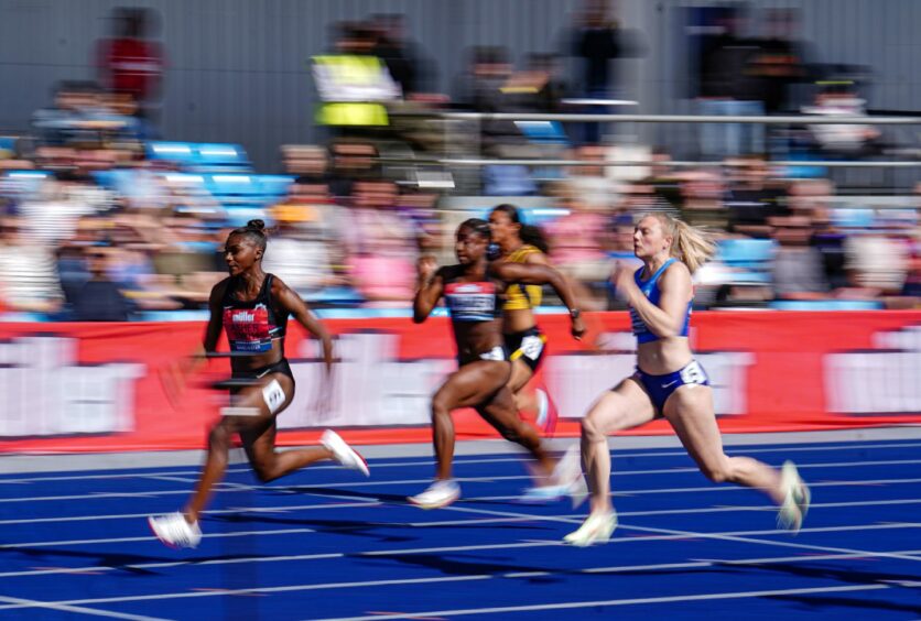 Alisha Rees, closest to camera, chases down Dina Asher-Smith in the women's 100m semi-final in Manchester.