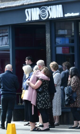 Mourners comforted each other outside Wendy Haggath's Symposium Coffee in Peterhead.