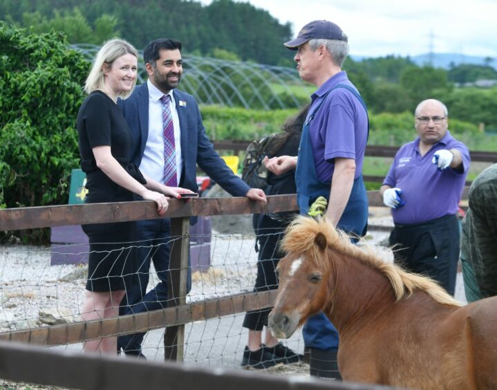 Jennifer Mitchell Director of External Relations with the VSA ,Health Minister Humza Yousaf and centre user Chris at Easter chatting at Anguston Farm next to a pony