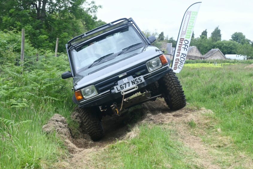 A Land Rover driving on uneven land.