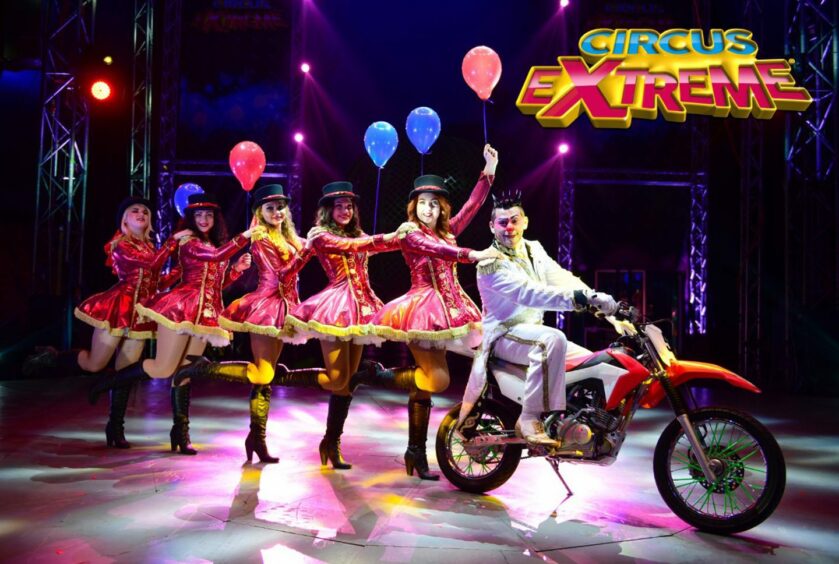 dancers trail clown on a motorcycle in Circus Extreme