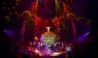 performers pose with sphere on stage at Circus Extreme