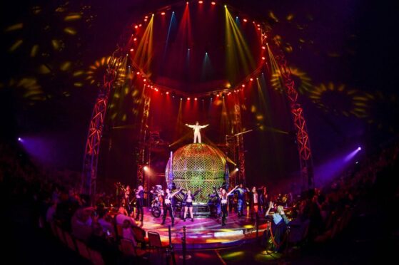 performers pose with sphere on stage at Circus Extreme