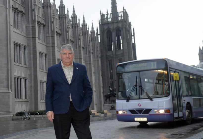Sir Moir Lockhead standing with a FirstGroup bus outside the Marischal College