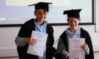 Finn Reid and Dave Brown, from Dunnottar Primary standing in gowns with certificates