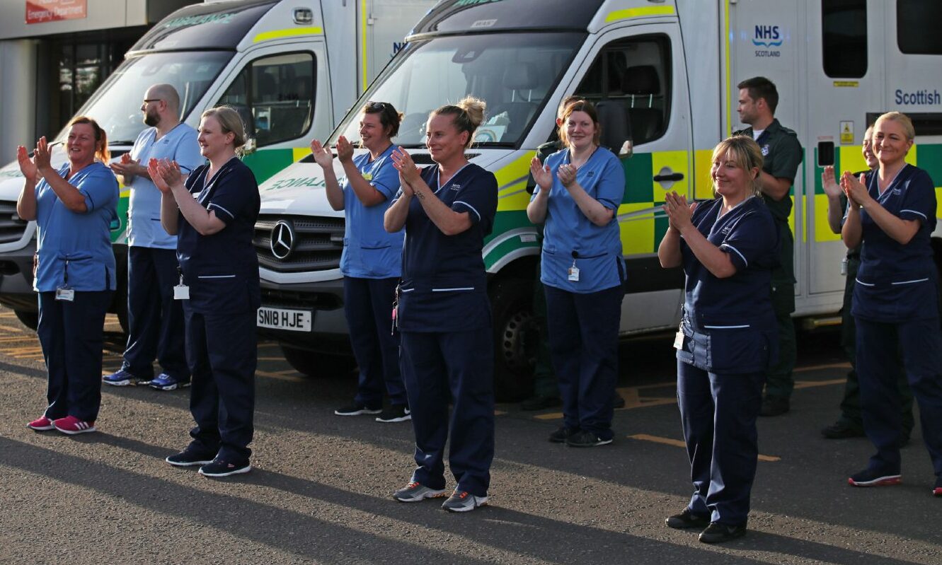 Staff from Queen Elizabeth University Hospital in Glasgow gather as they join in the applause to salute local heroes during Thursday's nationwide Clap for Carers to recognise and support NHS workers and carers fighting the coronavirus pandemic. PA Photo. Picture date: Thursday May 28, 2020.