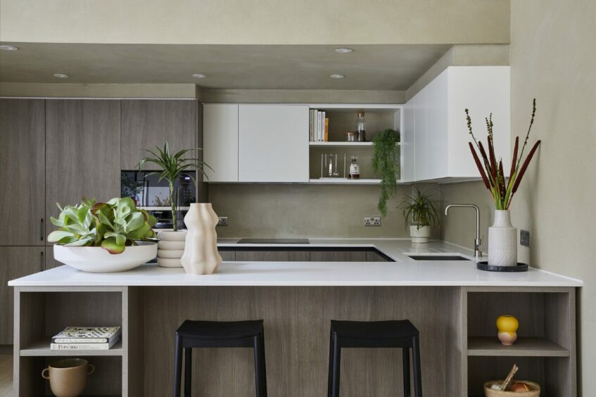 A modern kitchen with potted indoor plants on the kitchen island breakfast bar and ash wood tones