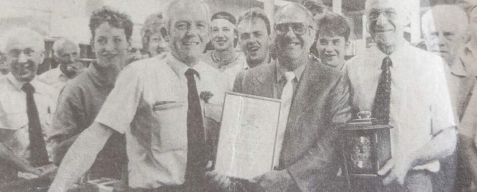A black and white picture depicting Harry Duncan of Turriff receiving his long service award from the Post Office.