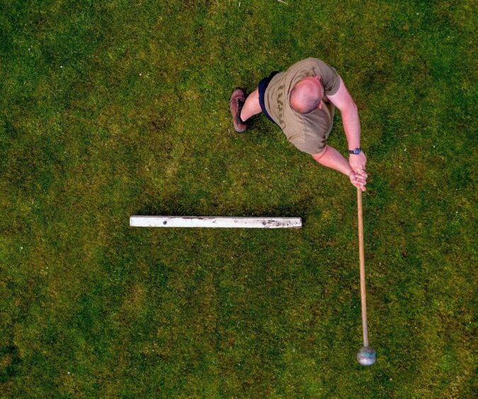 The athlete practicing swinging the hammer.