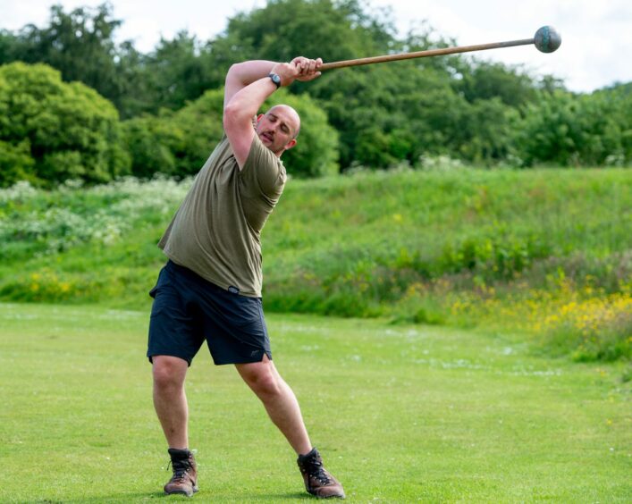 The athlete practicing swinging the hammer.