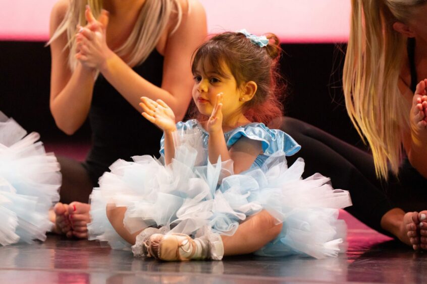A little ballet dancer claps along to the music.