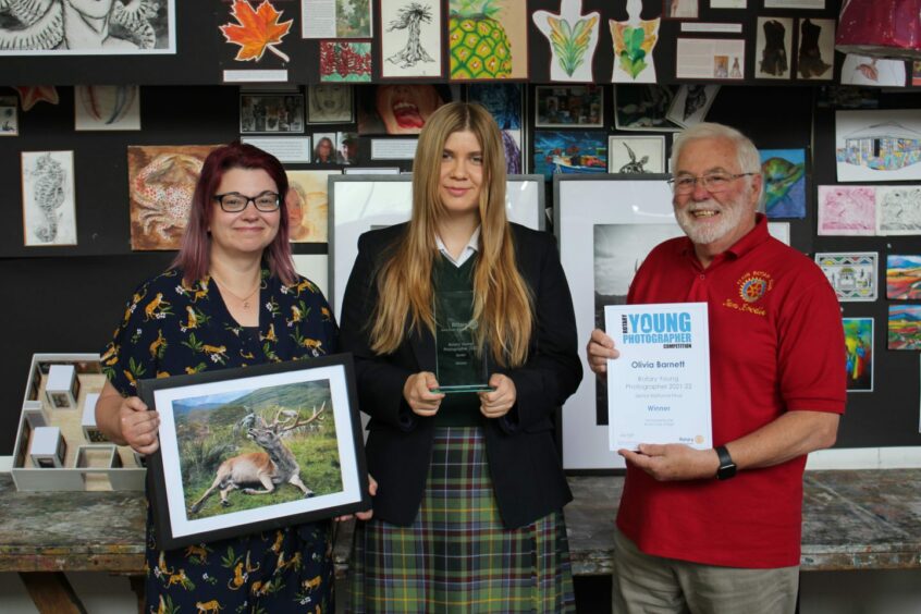 Olivia receives her trophy from Elgin Rotary President Ian Brodie and her photography teacher Wendi van Hoof.