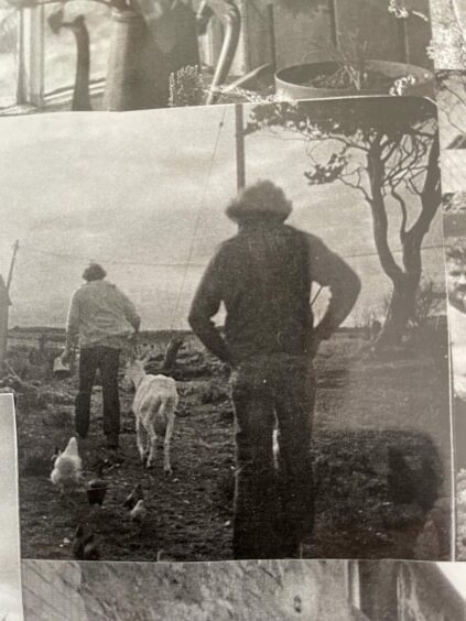 An old photograph of wo men herding goats.