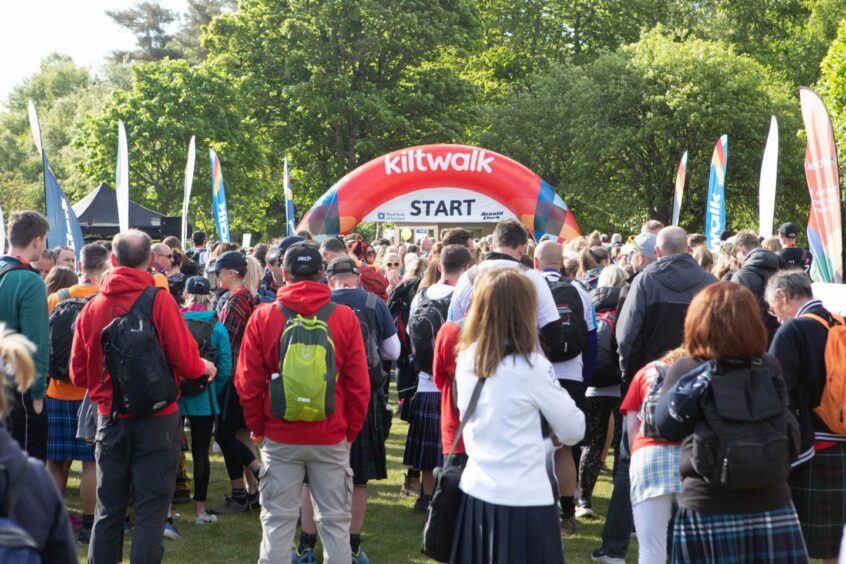 A crowd standing in front of the starting line of the Friends of Anchor Kiltwalk