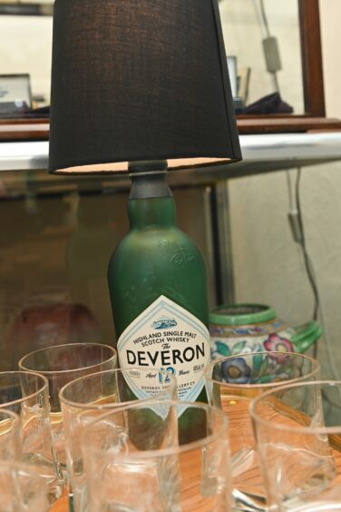 A unique lamp made out of a Deveron Scottish Whiskey bottle surrounded by glasses