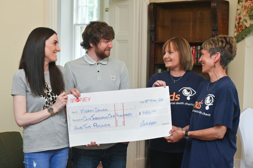 Leonie and Shane hand over cheque to Sands befrienders