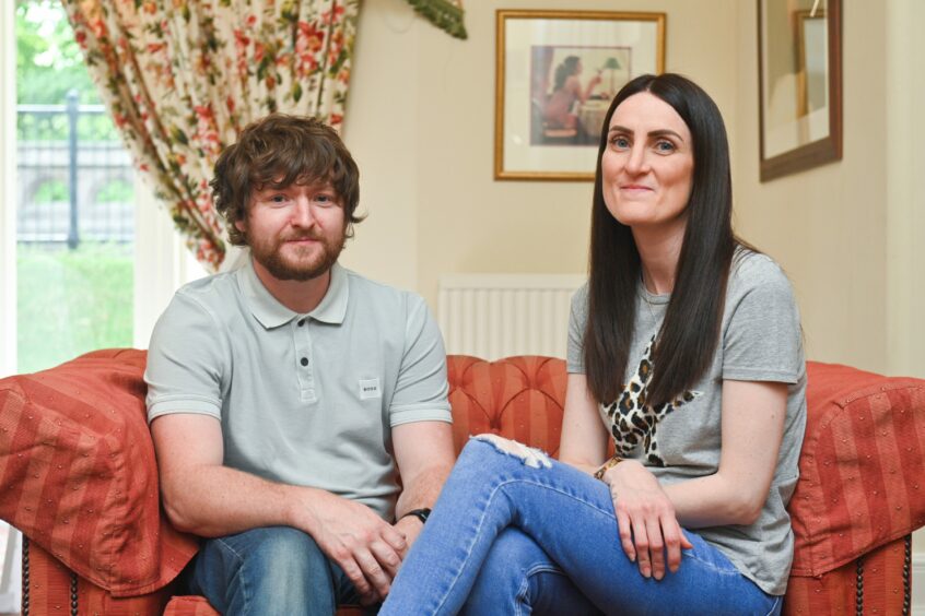 Leonie Wilson and her partner Shane Donaldson sitting on a sofa