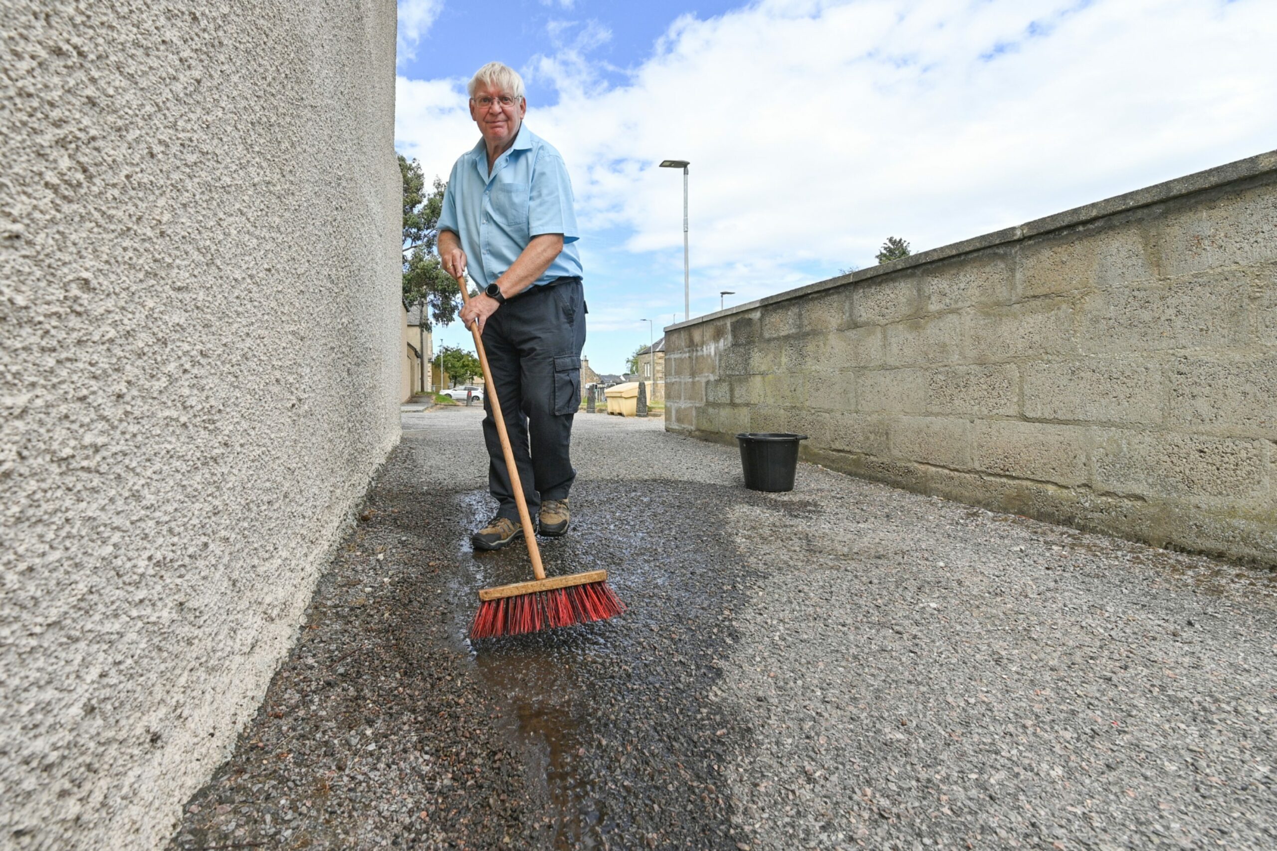 Elgin resident David Keeler sweeping outside his Elgin home after seagulls caused mess