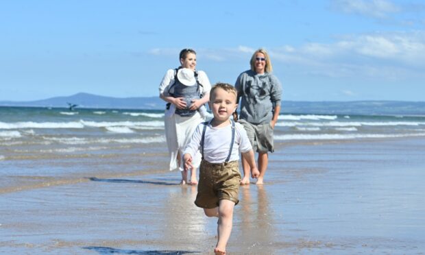 Caroline Gee with her new born Alfie and older son Arthur and friend Claire McNab all from Elgin enjoy a paddle at Lossie East Beach. Picture by Jason Hedges.