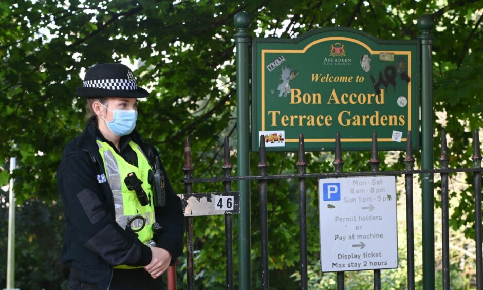 A policewoman standing next the Bon Accord Terrace Gardens sign