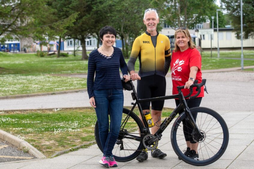 Iain's wife Michelle Masson, Buchan Dirlers Cycling Club chairman Ian Laidlaw and Iain's sister Wendy Del Testa standing with a bike
