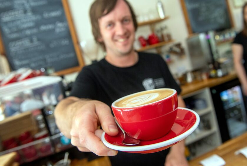 Jonny from Coffee Apothecary holding a cup of coffee