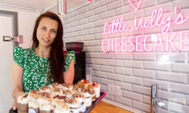Monika Zupranski at her Little Molly's Cheesecake business holding a tray of desserts.