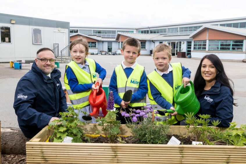 Blooming brilliant: Barry Kane (left) site manager at the Stewart Milne Homes Charleston development, and Tanya Fowlie, sales manager at Stewart Milne Homes with some of the budding gardeners at Charleston School.