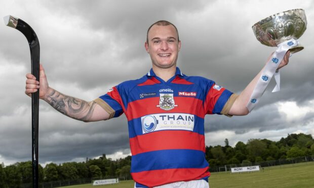 A delighted KIngussie captain Savio Genini with the MacTavish Cup. Image: Neil G Paterson