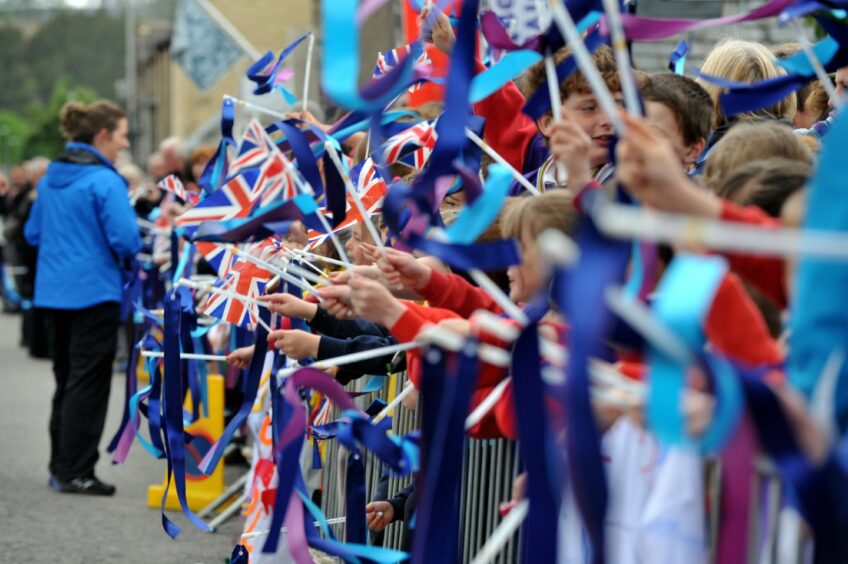 In 2012 Tomintoul school children wave the union jack flags waiting for the Olympic torch to reach their village.