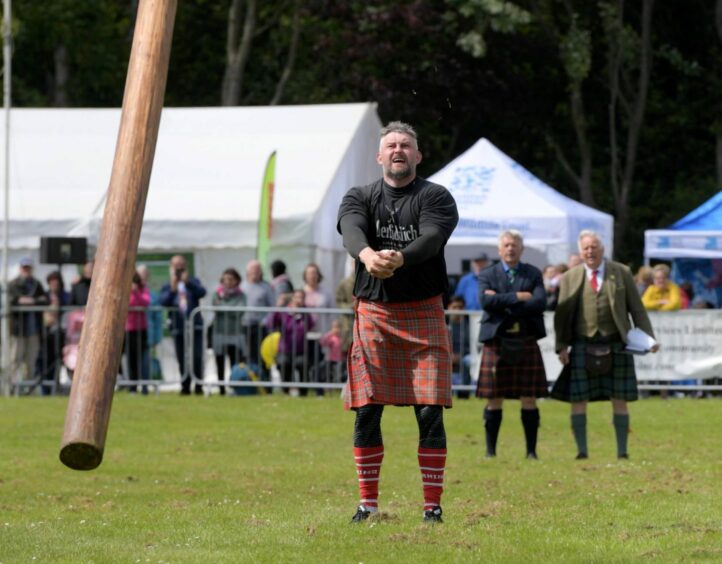 Lukaz Wenta tossing the caber at the Aberdeen Highland Games