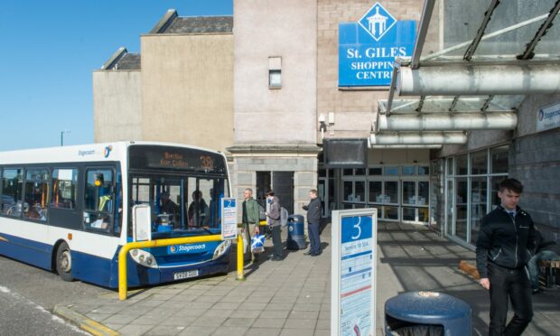 Buses parked at Elgin bus station with passengers queuing.