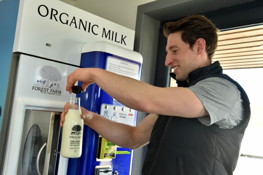 Owner Angus Willis using the milk vending machine in 2018.