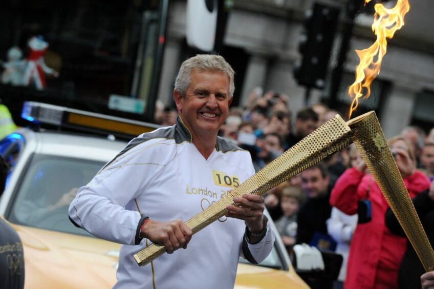 Colin Montgomerie carries the Olympic torch in Aberdeen in 2012.