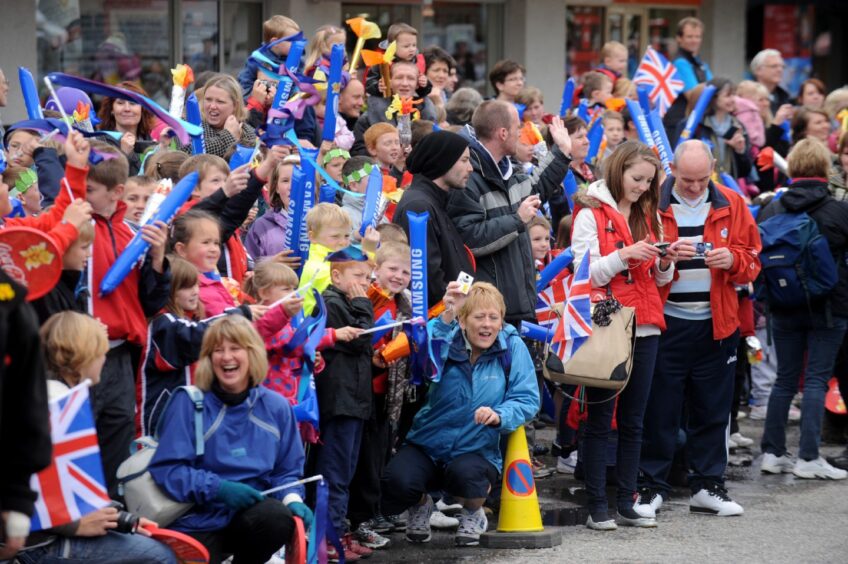 Pupils of Kingussie primary school cheer on the Olympic flame.