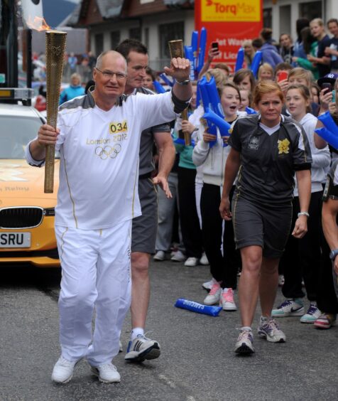 Jimmy Mackay carries the torch through Aviemore in 2012.