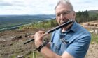 Larry Smith playing his Celtic pipe, part of his missing luggage