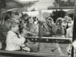 Prince William waving at the crowds from the car, where he was sitting inbetween The Queen and the Duke of Edinburgh. The Royal family were going to Crathie Church. 6 September 1987.